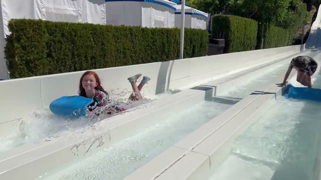 People sliding down water channels at a summer resort