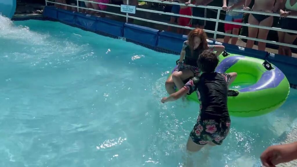 Two people enjoy a float in a pool on a cruise ship.