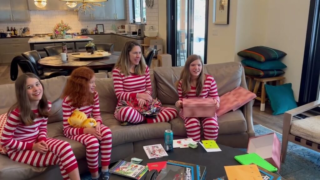 Relaxing in matching red and white striped pajamas on the couch during a cozy family morning.